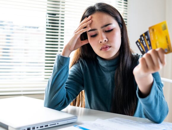 A woman looks stressed over her credit cards